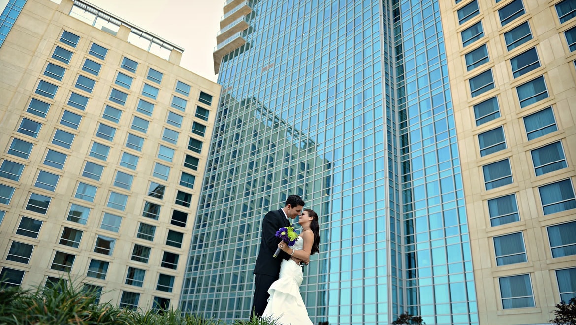 Bride and groom in the garden in front of Fort Worth hotel 